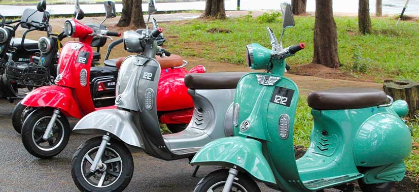 Motocicletas elétricas do tipo scooter de cores variadas lado a lado