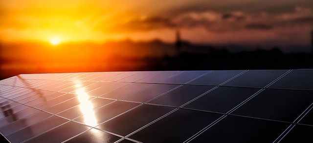 Paineis solares e um por do sol ao fundo